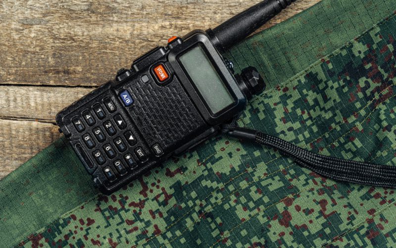 walkie-talkie-military-uniform-wooden-surface-top-view