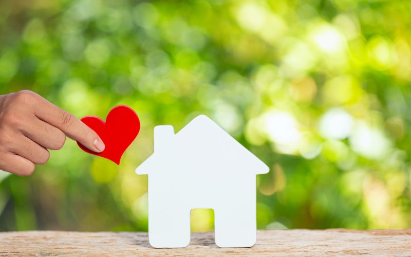 world-habitat-day-close-up-picture-model-house-hand-holding-paper-heart